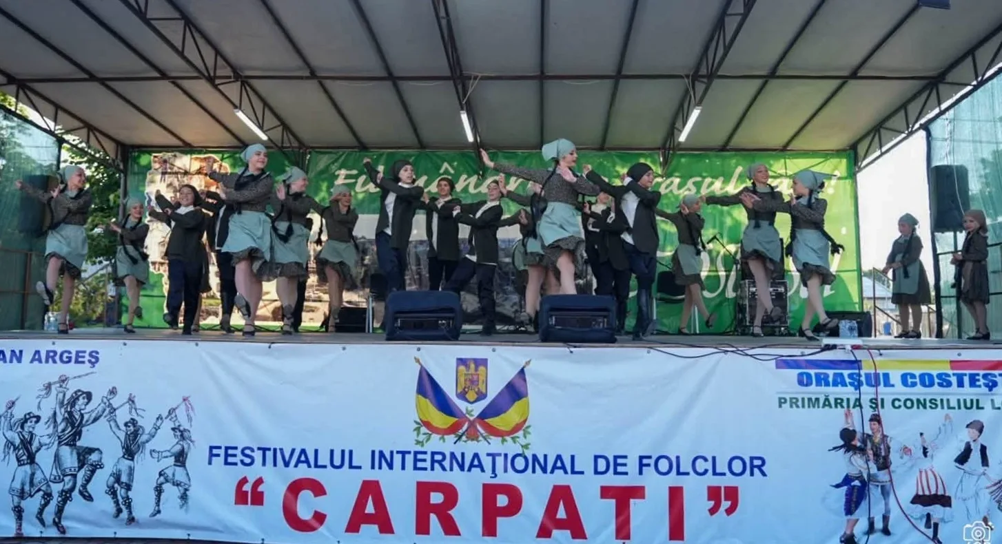 Ansamblul „Alilo” din Georgia evoluând pe scena Festivalului Internațional de Folclor „Carpați” la Costești, în 10 iulie 2026.